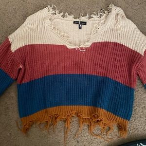Cropped and distressed long sleeve knitted off the shoulder sweater
